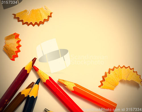 Image of several aged pencils and shavings on white background