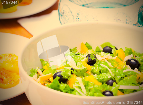 Image of Assorted salad of green leaf lettuce with squid and black olives