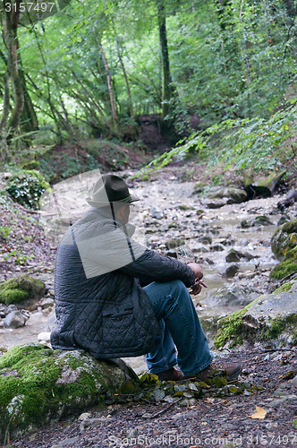 Image of Eldery man sitting in forest