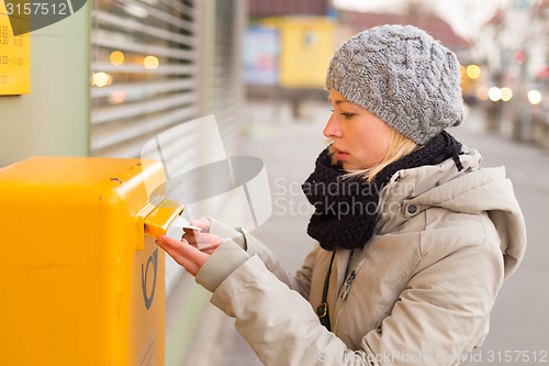 Image of Young lady posting letters. 