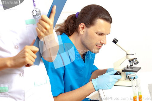 Image of scientist looking through a microscope