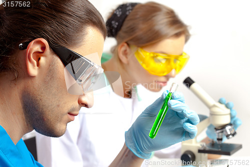 Image of Male researcher analyzes tubes