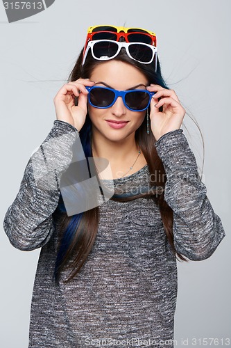 Image of Smiling woman wearing many colourful sunglasses