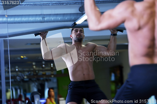 Image of handsome man exercising at the gym