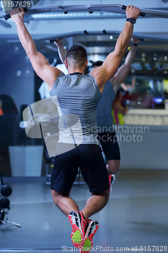 Image of handsome man exercising at the gym