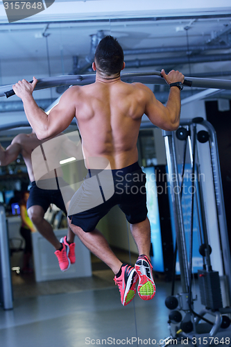 Image of handsome man exercising at the gym