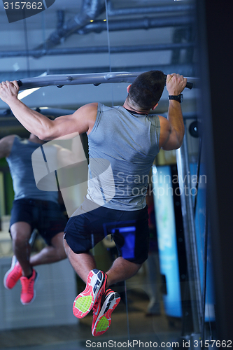 Image of handsome man exercising at the gym