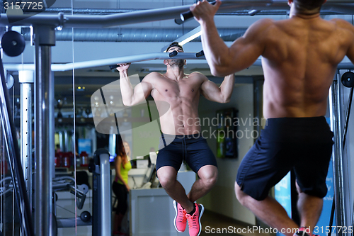 Image of handsome man exercising at the gym