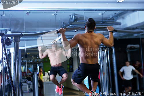 Image of handsome man exercising at the gym