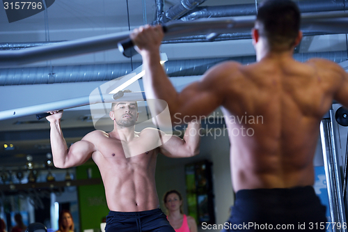 Image of handsome man exercising at the gym