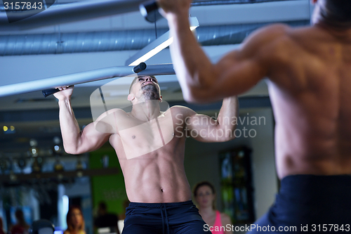 Image of handsome man exercising at the gym