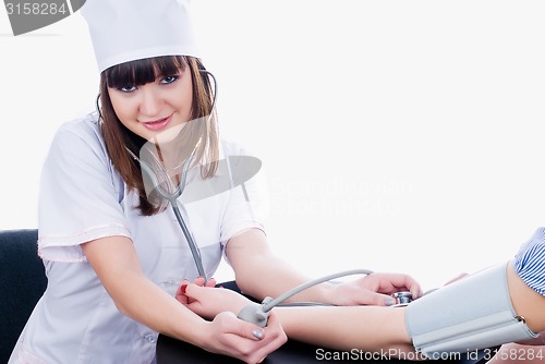 Image of Pretty young doctor measures pressure