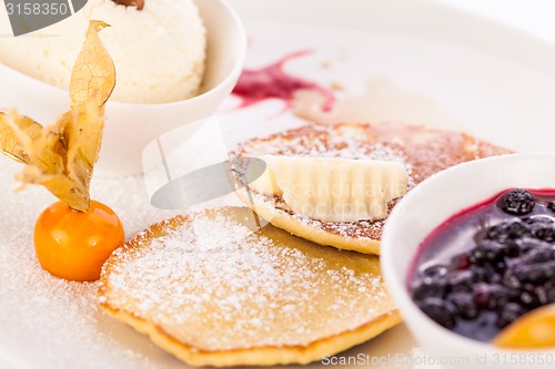 Image of tasty sweet pancakes with vanilla icecream and topping