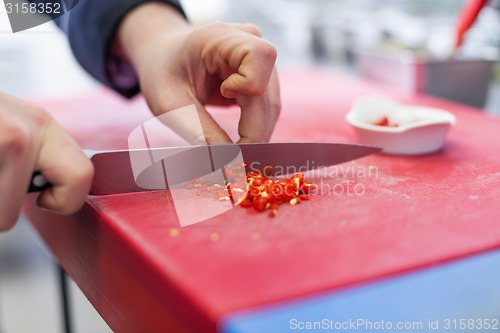 Image of Chef dicing red hot chili peppers