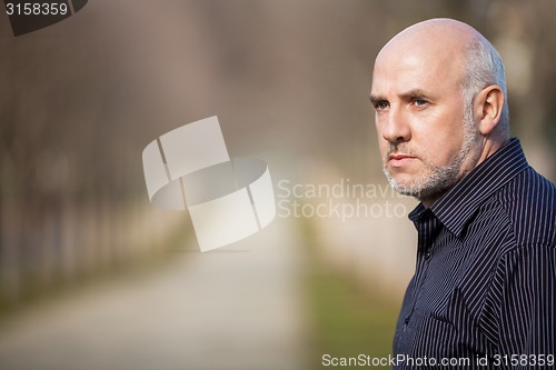 Image of Confident attractive man standing waiting