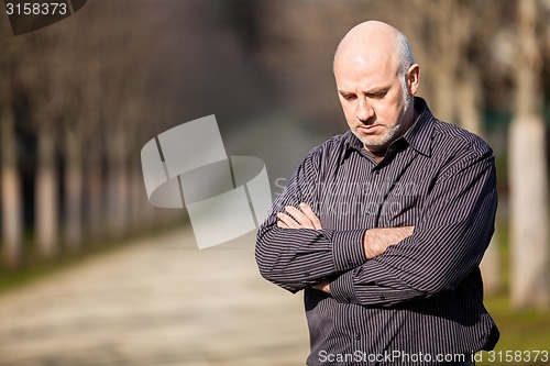 Image of Confident attractive man standing waiting