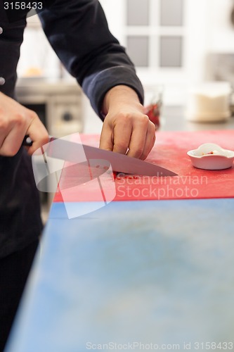 Image of Chef dicing red hot chili peppers