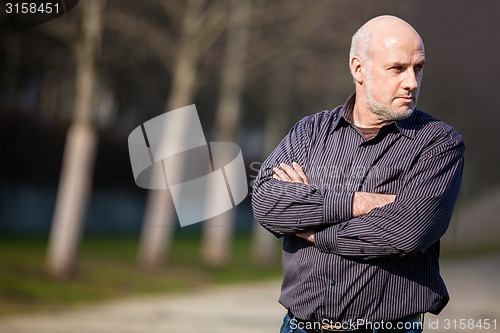 Image of Confident attractive man standing waiting