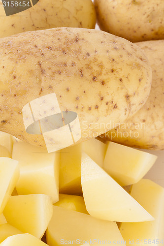 Image of Whole Potatoes and Chopped Pieces on Cutting Board