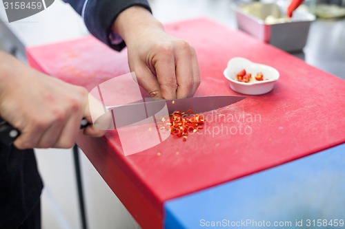 Image of Chef dicing red hot chili peppers