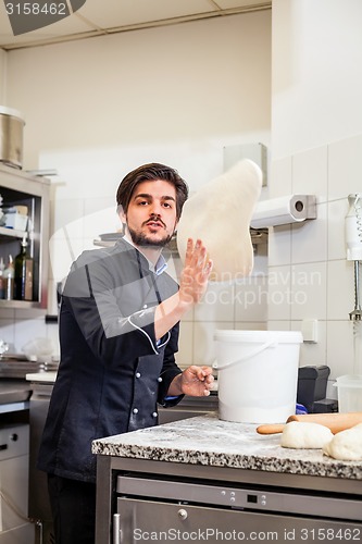 Image of Chef tossing dough while making pastries