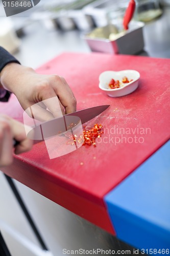 Image of Chef dicing red hot chili peppers