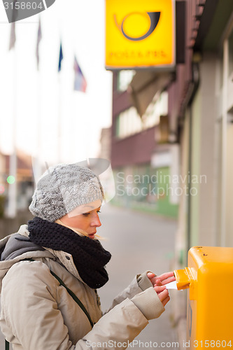 Image of Young lady posting letters. 