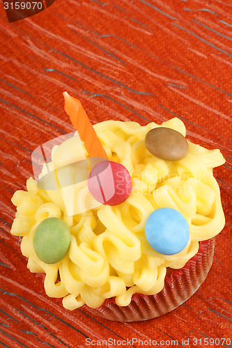 Image of Fancy birthday cupcake with orange candle