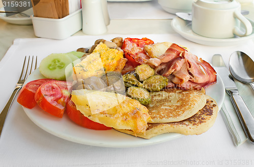 Image of Meat, fish and various vegetable garnish on a plate.