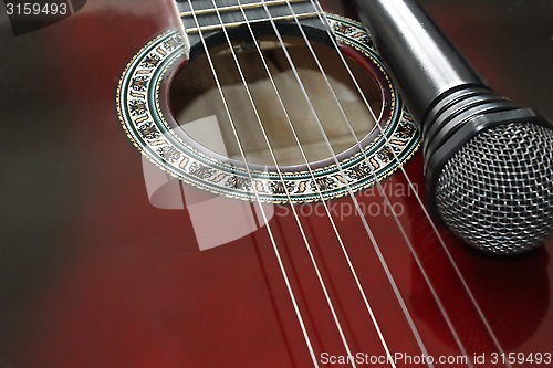 Image of dark guitar and microphone