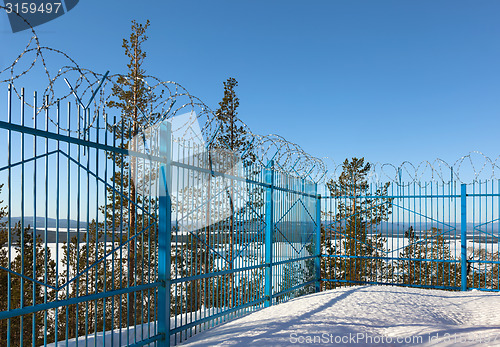 Image of closed area behind a fence topped with barbed wire