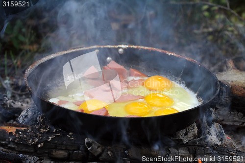 Image of An unusual way of cooking eggs on  fire