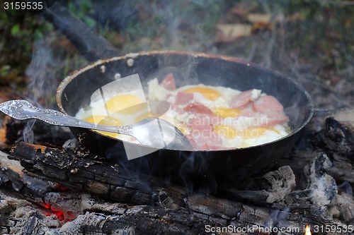 Image of An unusual way of cooking eggs on  fire