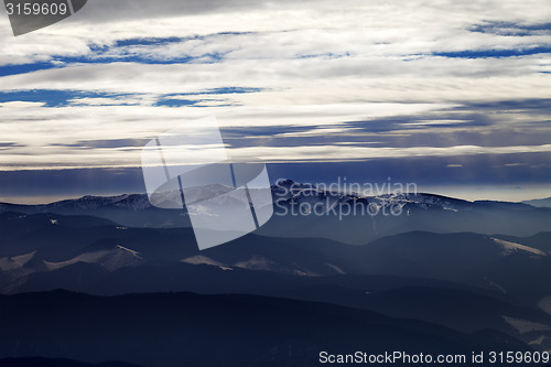 Image of Silhouettes of cloudy mountains in evening