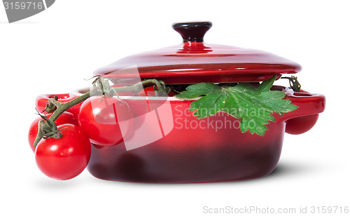 Image of Cherry tomatoes on stem and parsley in saucepan