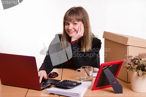Image of Smiling girl sitting in office at computer