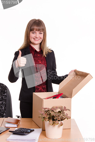 Image of The girl behind the office desk with a box showing thumb