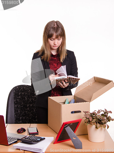 Image of Dismissed girl in office goes through personal belongings