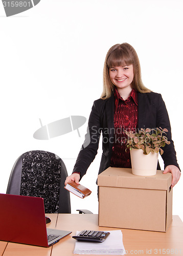 Image of Adopted at work in office girl puts things out of box