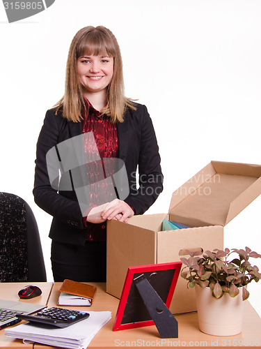 Image of Girl standing behind an office desk with a big box