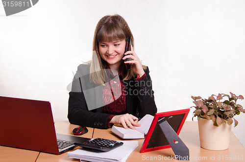 Image of The girl behind office desk talking on phone