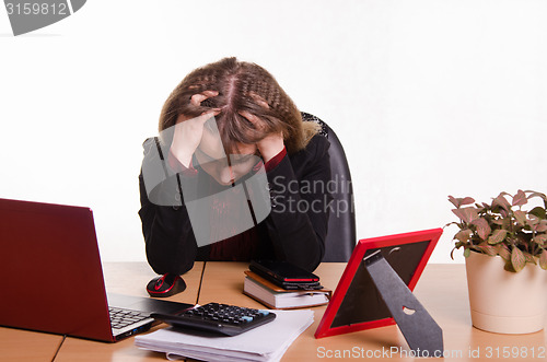 Image of girl behind office desk grabbed head in his hands