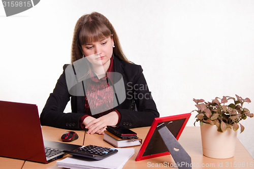 Image of Detached woman sitting at office table