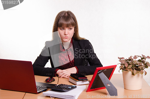 Image of Thoughtful girl sitting at office desk