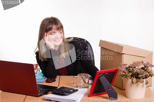 Image of Smiling office employee looks at the picture frame