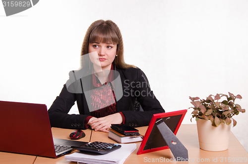 Image of Thoughtful girl sitting at office desk