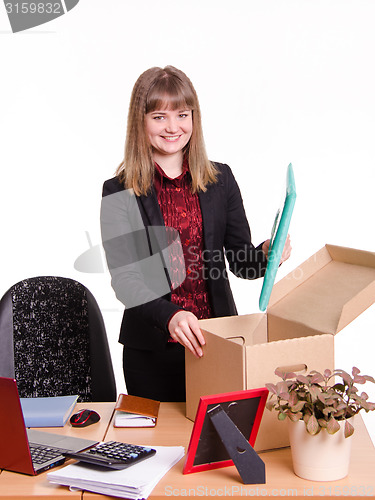 Image of New employee in office puts his things out of box