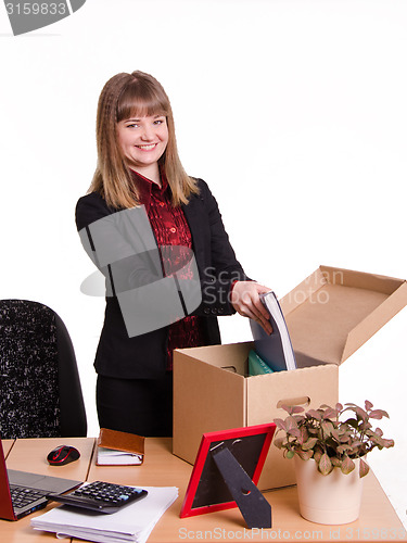 Image of Adopted in office girl puts her things out of the box