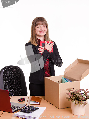 Image of Girl puts a photo frame on desktop in office