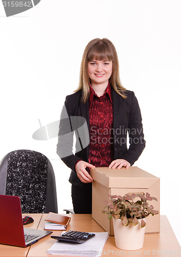 Image of Smiling girl at office desk with a big box